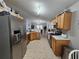 Well-lit kitchen featuring stainless steel appliances, tile flooring, and oak cabinets at 2413 Sandridge Cir, Eustis, FL 32726