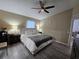 Cozy main bedroom features wood floors, ceiling fan, and a view to the ensuite bathroom at 2413 Sandridge Cir, Eustis, FL 32726