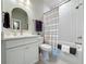 Well-lit bathroom featuring a shower-tub combo, a toilet and a vanity with a mirror at 2842 Purple Meadow Ct, Minneola, FL 34715