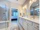 Bright bathroom showcasing double vanities, gold fixtures, framed mirrors and an adjacent bedroom at 2842 Purple Meadow Ct, Minneola, FL 34715