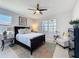 Cozy bedroom with a dark bed frame, a ceiling fan, and a beautiful view from the windows at 2842 Purple Meadow Ct, Minneola, FL 34715