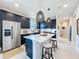 Modern kitchen features dark cabinetry, stainless steel appliances, quartz countertops, and pendant lighting at 2842 Purple Meadow Ct, Minneola, FL 34715