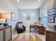 Bright home office featuring a sleek desk, a comfy chair and modern light fixtures at 2842 Purple Meadow Ct, Minneola, FL 34715