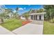 A single-story home features a driveway, carport, and a well-manicured front lawn with palm trees at 3107 Martinique Way, Orlando, FL 32805