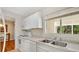 Bright kitchen with white cabinets, stainless sink, and natural light coming through the window at 3107 Martinique Way, Orlando, FL 32805