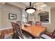 Open dining room with wood table, chandelier, view to living area, and decorative wrought iron feature at 3334 Park Grove Ct, Longwood, FL 32779