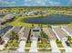 Aerial view of the neighborhood shows the houses with solar panels, a lake, and a golf course at 3415 Sagebrush St, Harmony, FL 34773