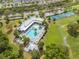 Aerial view showcases a community pool and tennis courts surrounded by lush landscaping and nearby parking at 3415 Sagebrush St, Harmony, FL 34773