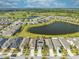 An aerial view shows a neighborhood with a lake, golf course, and well-maintained lawns at 3415 Sagebrush St, Harmony, FL 34773