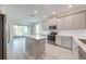 Bright kitchen featuring stainless appliances, gray cabinets, an island, and sliding doors to the lanai at 3415 Sagebrush St, Harmony, FL 34773