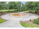 Community splash pad featuring a water fountain, benches, and paved walkways surrounded by lush landscaping and mature trees at 3415 Sagebrush St, Harmony, FL 34773