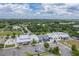 Aerial view of a community town market with various shops, ample parking, and surrounding landscape at 3415 Sagebrush St, Harmony, FL 34773