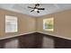 Bright bedroom featuring hardwood floors, two large windows, and overhead fan with lighting at 346 Vista Oaks Way, Davenport, FL 33837