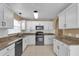 Bright kitchen with white cabinets, granite countertops, and modern appliances at 346 Vista Oaks Way, Davenport, FL 33837