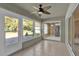 Bright sunroom featuring tile flooring, a ceiling fan, and views of the lush outdoor space at 346 Vista Oaks Way, Davenport, FL 33837