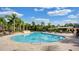 A large community pool with chairs and tables surrounded by beautiful palm trees and greenery at 3734 Safflower Terrace, Oviedo, FL 32766