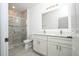 Modern bathroom featuring a double vanity, stylish mirror, and a glass-enclosed shower with elegant tiling at 3922 Sw 130Th Loop, Ocala, FL 34473