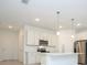 Modern kitchen with white cabinets, stainless steel appliances, and a center island with pendant lighting at 3922 Sw 130Th Loop, Ocala, FL 34473