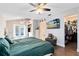 Large main bedroom featuring wood floors, a ceiling fan, television, and closet space at 409 Surrey Run, Casselberry, FL 32707