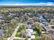 An aerial view displays a residential area with houses surrounded by trees under a vast blue sky at 418 Norwood Ct, Oviedo, FL 32765