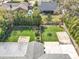 An aerial view of a lush backyard with manicured lawn and greenery, featuring a patio area and privacy landscaping at 418 Norwood Ct, Oviedo, FL 32765