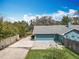 Exterior view features a blue painted home with a two car garage and lush landscaping at 418 Norwood Ct, Oviedo, FL 32765