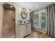 Bright bathroom featuring a walk-in shower, vanity with stylish mirror, and hardwood floors at 421 Broadway Ave, Orlando, FL 32803