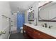 Modern bathroom with double vanity, dual mirrors, sleek fixtures, and a tiled shower at 421 Broadway Ave, Orlando, FL 32803