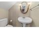 Cozy bathroom features a pedestal sink with an oval mirror and a toilet at 421 Broadway Ave, Orlando, FL 32803