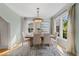 Sunlit dining room with a wooden table, neutral chairs, and large windows at 421 Broadway Ave, Orlando, FL 32803