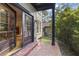 Exterior view of home entrance featuring a brick patio, dark door, and lush landscaping at 421 Broadway Ave, Orlando, FL 32803