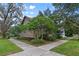 Beautiful home nestled among mature trees with a well-maintained lawn and crosswalk at 421 Broadway Ave, Orlando, FL 32803