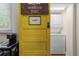 Quaint laundry area with a bright yellow door and convenient washer and dryer setup at 421 Broadway Ave, Orlando, FL 32803