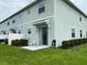 Exterior of townhome with sliding glass doors to patio and green grass at 4724 Tribute Trl, Kissimmee, FL 34746