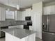 Bright, modern kitchen with white cabinetry, stainless appliances, and sleek countertops at 4724 Tribute Trl, Kissimmee, FL 34746