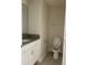 Neutral powder room featuring a granite vanity, white cabinets, and a modern toilet at 4724 Tribute Trl, Kissimmee, FL 34746