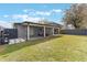 Spacious backyard featuring a covered patio with outdoor seating, lush green grass, and privacy fence at 4909 Fiske Cir, Orlando, FL 32826