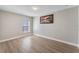 Bedroom with wood-look flooring, a window with blinds, and a landscape painting at 4909 Fiske Cir, Orlando, FL 32826