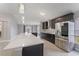 Modern kitchen featuring stainless steel appliances, dark cabinets, and a large island with quartz countertops at 4909 Fiske Cir, Orlando, FL 32826