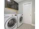 Laundry room with stacked washer and dryer and overhead cabinet storage at 4909 Fiske Cir, Orlando, FL 32826