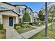 Charming townhome featuring colorful exterior, blue door, manicured landscaping, and sidewalks at 5025 Walker St, St Cloud, FL 34771