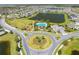 Aerial view showcasing a community pool, playground, large pond, and green spaces in a residential neighborhood at 5301 Amersham Ln, St Cloud, FL 34771