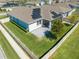 Aerial view of a property featuring a pristine lawn, modern solar panels, and a screened lanai at 5301 Amersham Ln, St Cloud, FL 34771