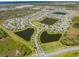 Aerial view of a residential community featuring multiple ponds and a community pool at 5301 Amersham Ln, St Cloud, FL 34771