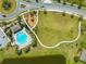 Aerial view of community amenities including a pool, playground, and roundabout in a neighborhood setting at 5301 Amersham Ln, St Cloud, FL 34771