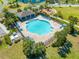 Aerial shot of a sparkling community pool with lounge chairs and lush landscaping at 5301 Amersham Ln, St Cloud, FL 34771