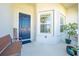 Welcoming front porch with bench, blue door, and decorative plants for a cozy entrance at 5301 Amersham Ln, St Cloud, FL 34771