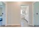 Hallway view leading to a bathroom, showing neutral wall color and tile flooring at 5301 Amersham Ln, St Cloud, FL 34771