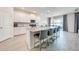 Open concept kitchen with white cabinets, pendant lights and kitchen island with bar stool seating at 5301 Amersham Ln, St Cloud, FL 34771