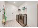 Bright laundry room featuring stainless steel washer and dryer set with white shelving and gray vinyl flooring at 5301 Amersham Ln, St Cloud, FL 34771